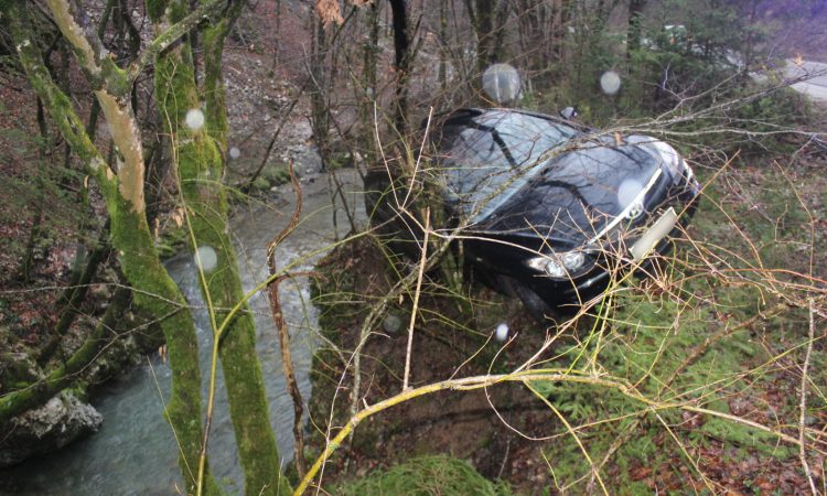 Zaradi neprilagojene hitrosti zapeljal s ceste in z avtomobilom obstal med drevesi nad potokom